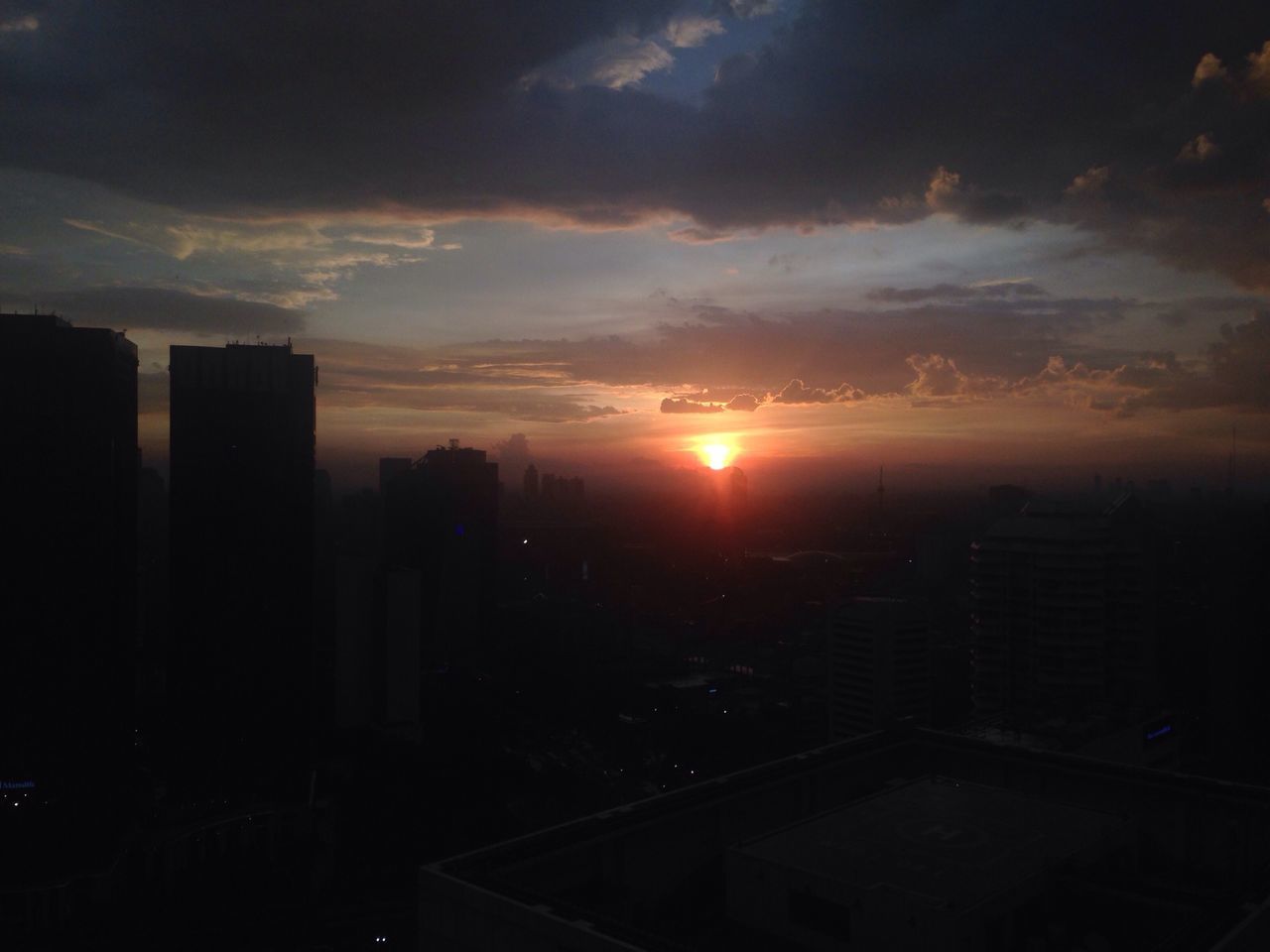 sunset, building exterior, architecture, built structure, sky, city, sun, cityscape, cloud - sky, silhouette, sunlight, residential building, orange color, residential structure, sunbeam, cloud, skyscraper, residential district, cloudy, outdoors