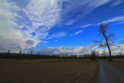 Road amidst field against sky