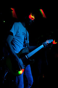 Person playing guitar at night