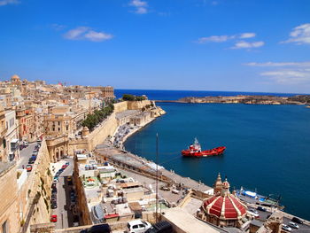 High angle view of cityscape by sea against sky