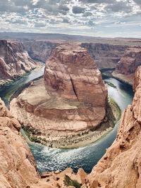 Aerial view of river flowing amidst canyon against sky