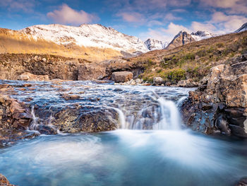 Scenic view of waterfall against sky during winter