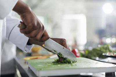 Cropped hand of man preparing food on table