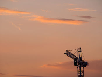 Low angle view of crane against sky during sunset