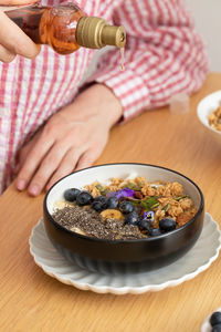 Cropped hand of person preparing food on table