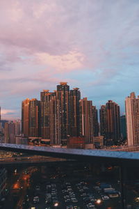 Modern buildings in city against sky during sunset
