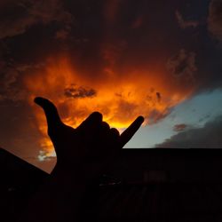 Low angle view of silhouette hand against sky during sunset