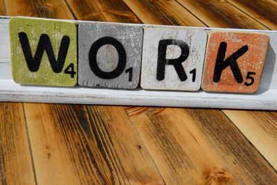 Close-up of text with toy blocks on wooden table