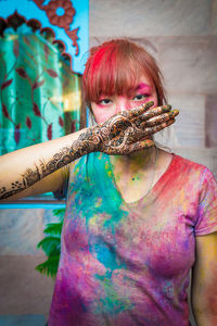 Portrait of young woman covered with powder paint during holi