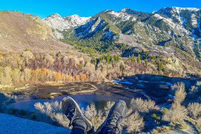 Low section of person by lake against mountains