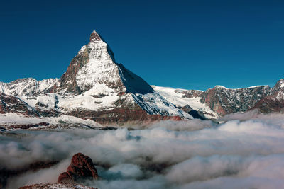 Scenic view of snowcapped mountain against clear blue sky