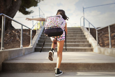 Rear view of woman walking on staircase