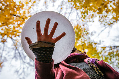 Close-up of person wearing hat against trees during winter