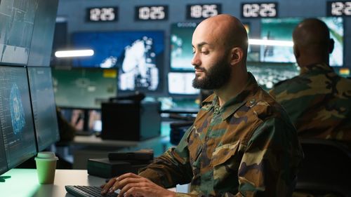 Side view of man standing in factory