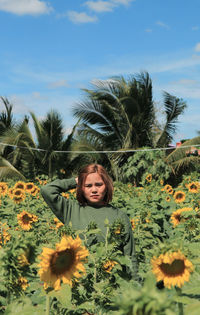 Portrait of woman with sunflower against sky