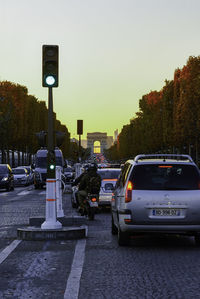 Traffic on road in city against clear sky