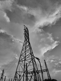 Low angle view of silhouette electricity pylon against sky