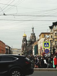 Cars on road in city against sky