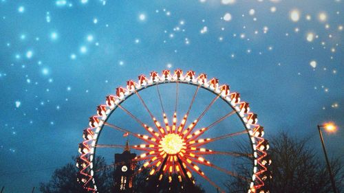 Low angle view of ferris wheel against sky at night