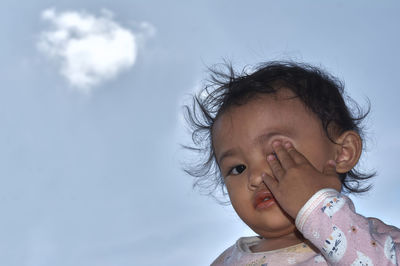 Portrait of cute girl against sky