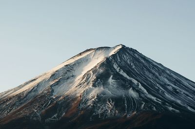 Low angle view of volcanic mountain against clear sky