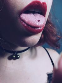 Close-up midsection of woman sticking out tongue