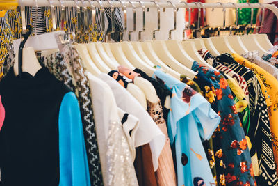 View of various clothes hanging for sale at market