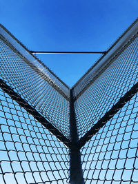 Low angle view of chainlink fence against sky