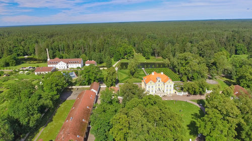 High angle view of green landscape and houses against sky