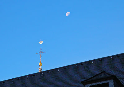 Low angle view of weather vane against sky