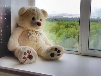 Close-up of stuffed toy on window sill at home