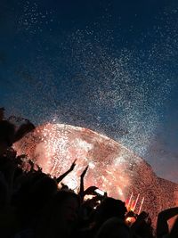 Low angle view of fireworks against sky at night