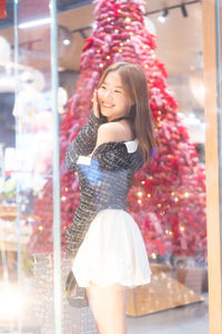 Portrait of young woman standing in city