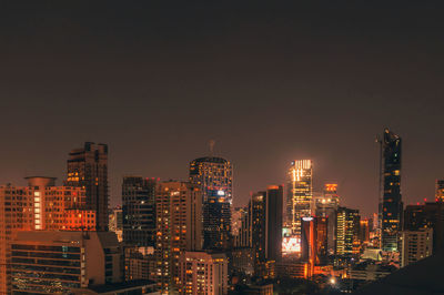 Illuminated cityscape against sky at night