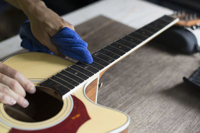 Midsection of person playing guitar on table