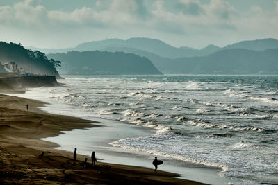 Scenic view of sea and mountains against sky