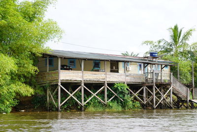 House by river against sky