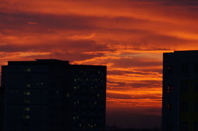 Silhouette buildings against orange sky