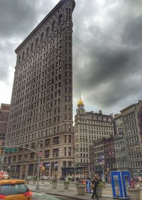 View of buildings in city against cloudy sky