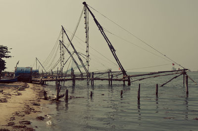 Fishing nets over sea against clear sky