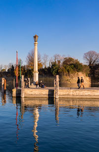 Gazebo in lake against clear blue sky