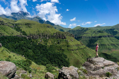 Rear view of woman standing on mountain against sky