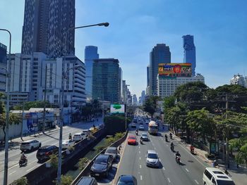 Traffic on city street amidst buildings against sky