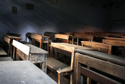 Empty wooden benches and table in classroom