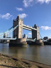 View of bridge over river against cloudy sky
