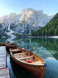 Boats moored in lake against mountains