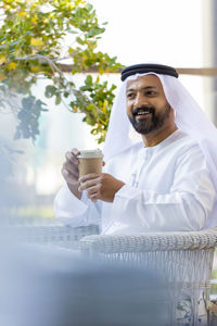 Man in traditional clothing sitting in cafe