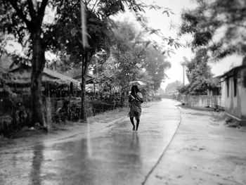 Woman walking on street in rain