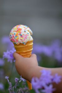 Close-up of hand holding ice cream cone outdoors