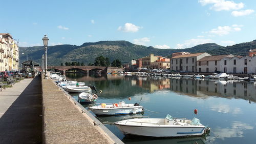 Boats moored in harbor by buildings in city